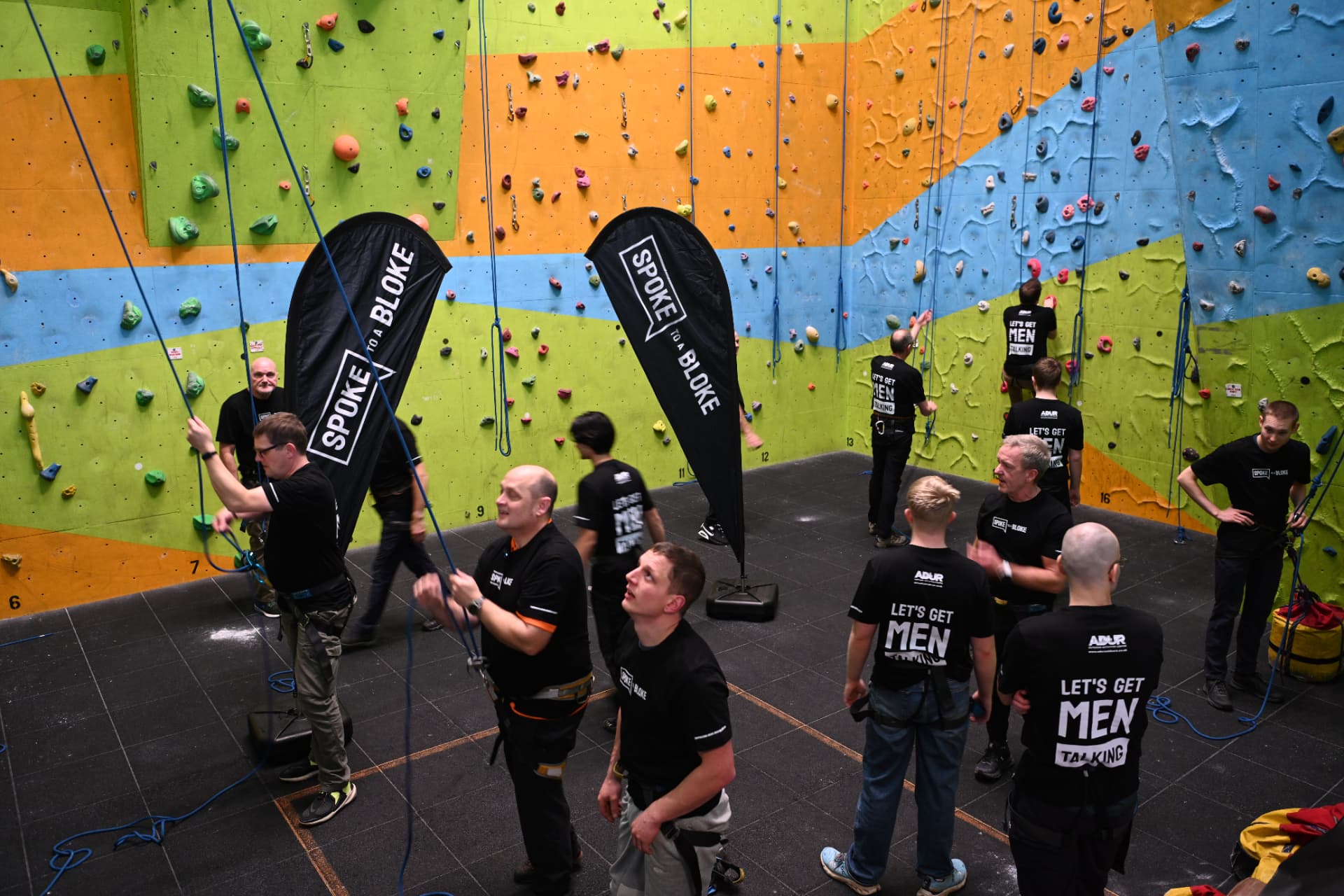 Men in Let's Get Men Talking shirts at a Spoke to a Bloke climbing event