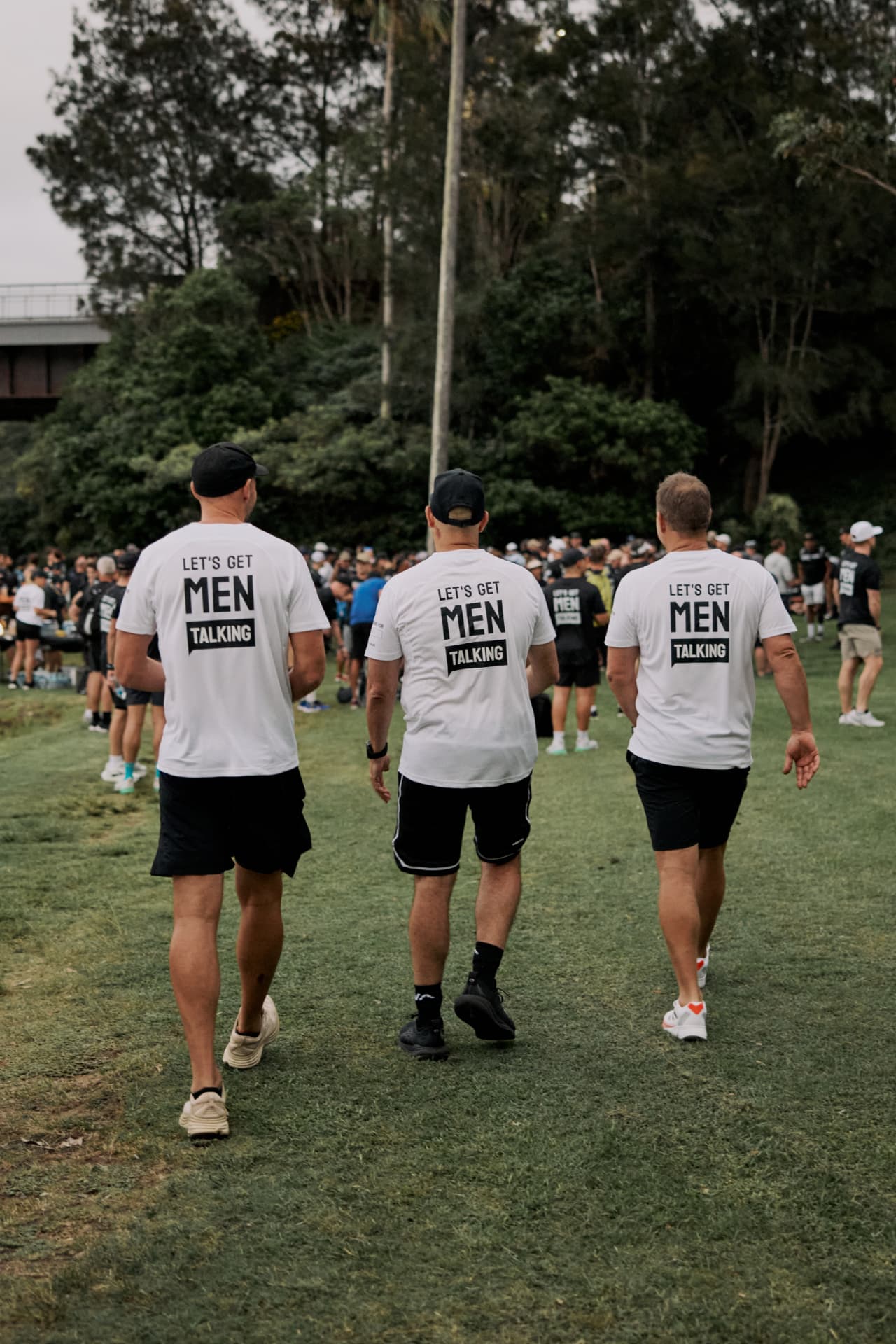 Blokes walking together in Let's Get Men Talking tees